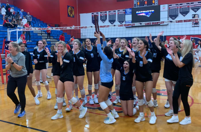 Hagerty libero Mayte Camacho holds up the Region 1-7A championship trophy after the Huskies defeated third-ranked Lake Brantley 26-28 25-15 25-23 25-16.